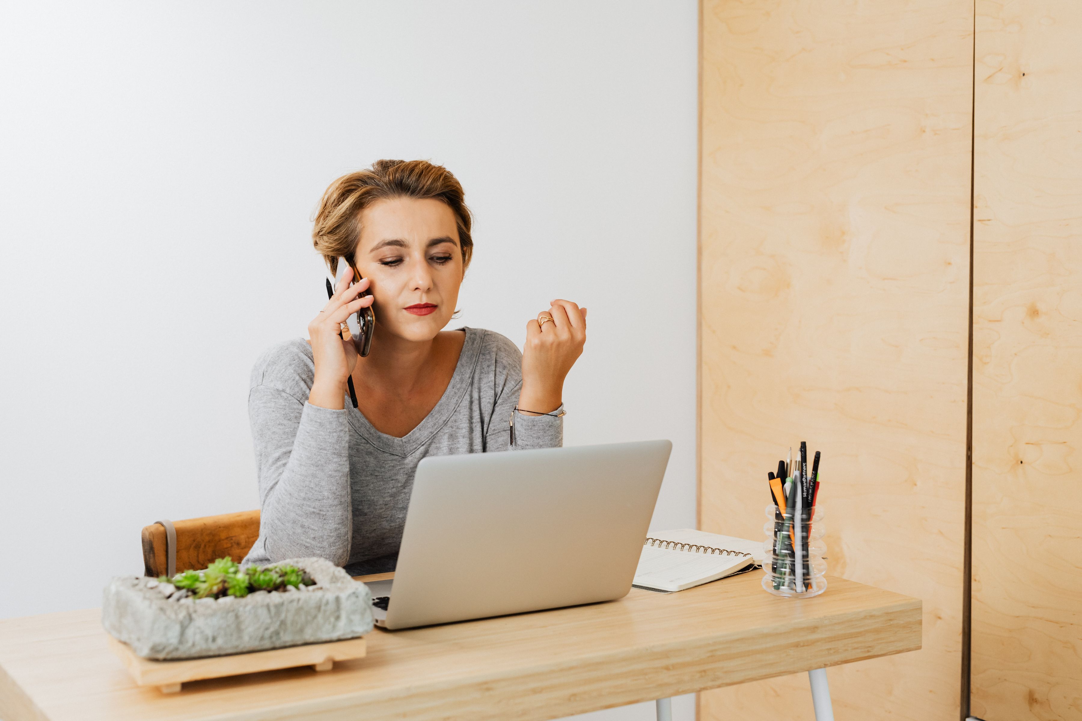 Office worker on a phone call at a laptop, representing automated recall outreach