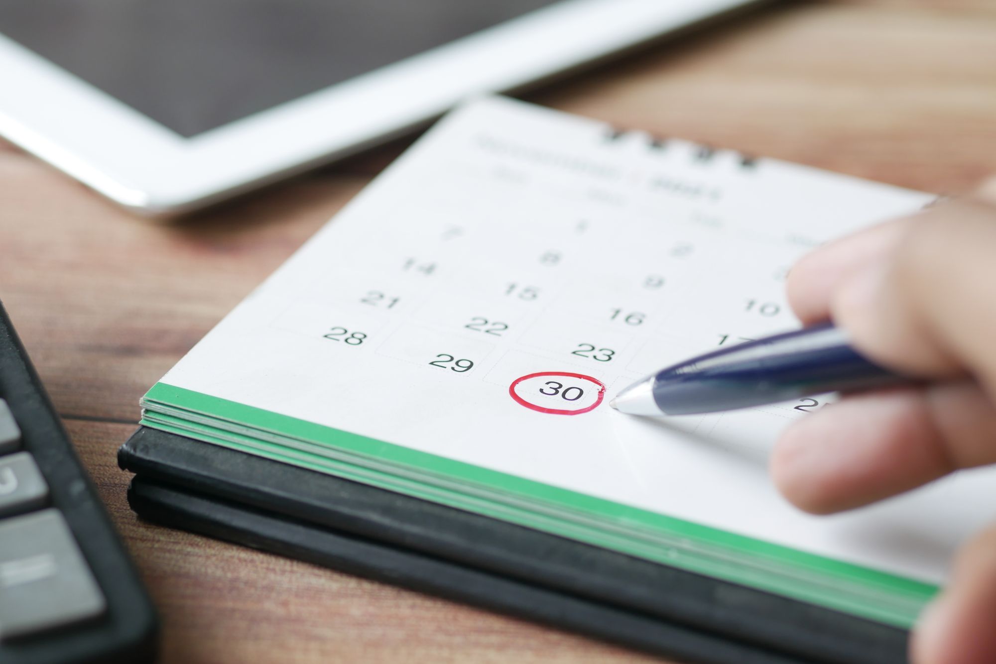 Pen circling an appointment date on a desk calendar