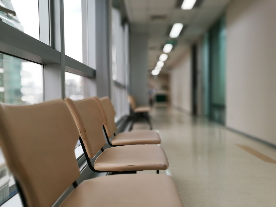 A row of empty waiting-room chairs in a clinic hallway