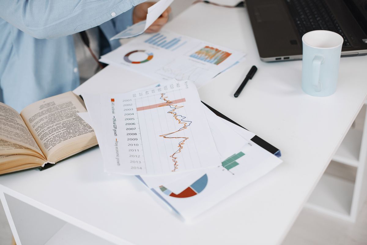 Business growth charts and reports spread across a desk